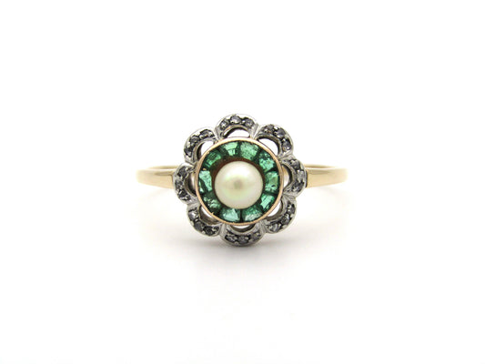 9K gold Edwardian pearl, emerald, and diamond flower ring, circa 1905.