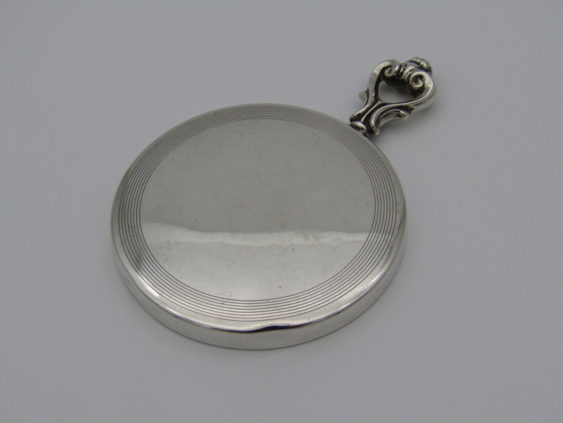 A sterling silver hand mirror by Cartier. Circa 1920s.