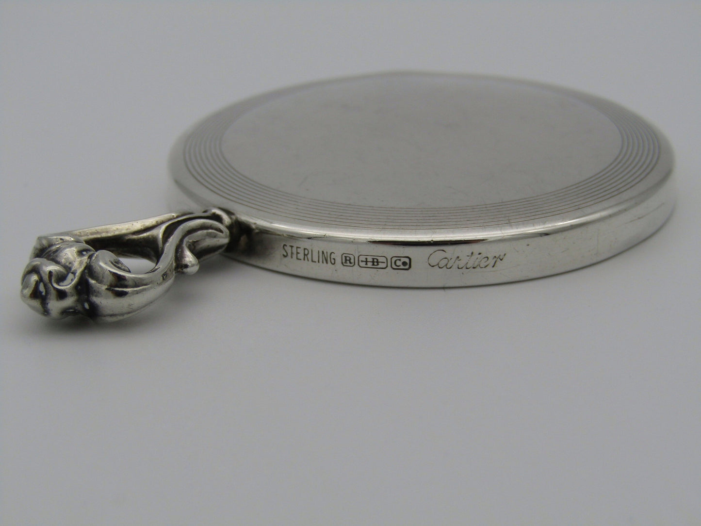 A sterling silver hand mirror by Cartier. Circa 1920s.