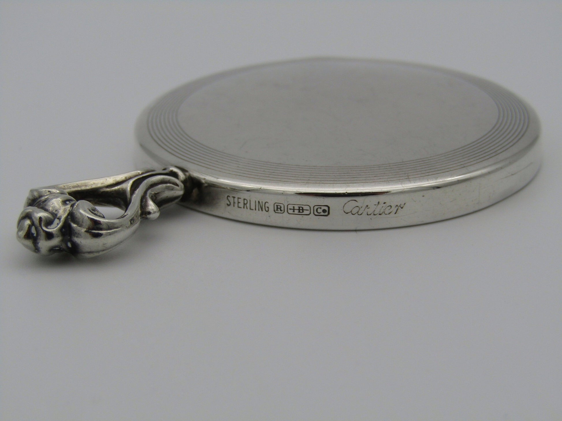 A sterling silver hand mirror by Cartier. Circa 1920s.