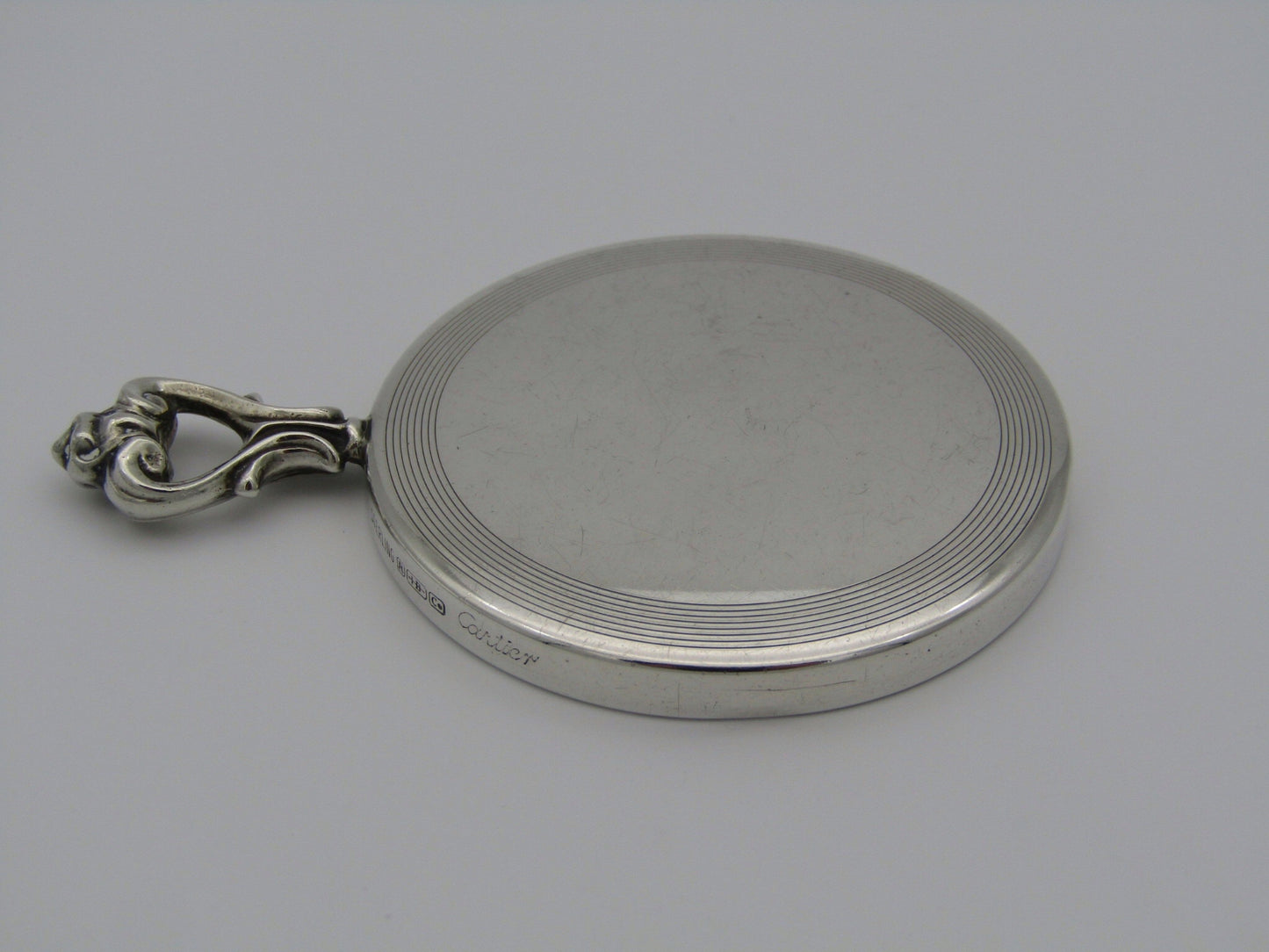A sterling silver hand mirror by Cartier. Circa 1920s.