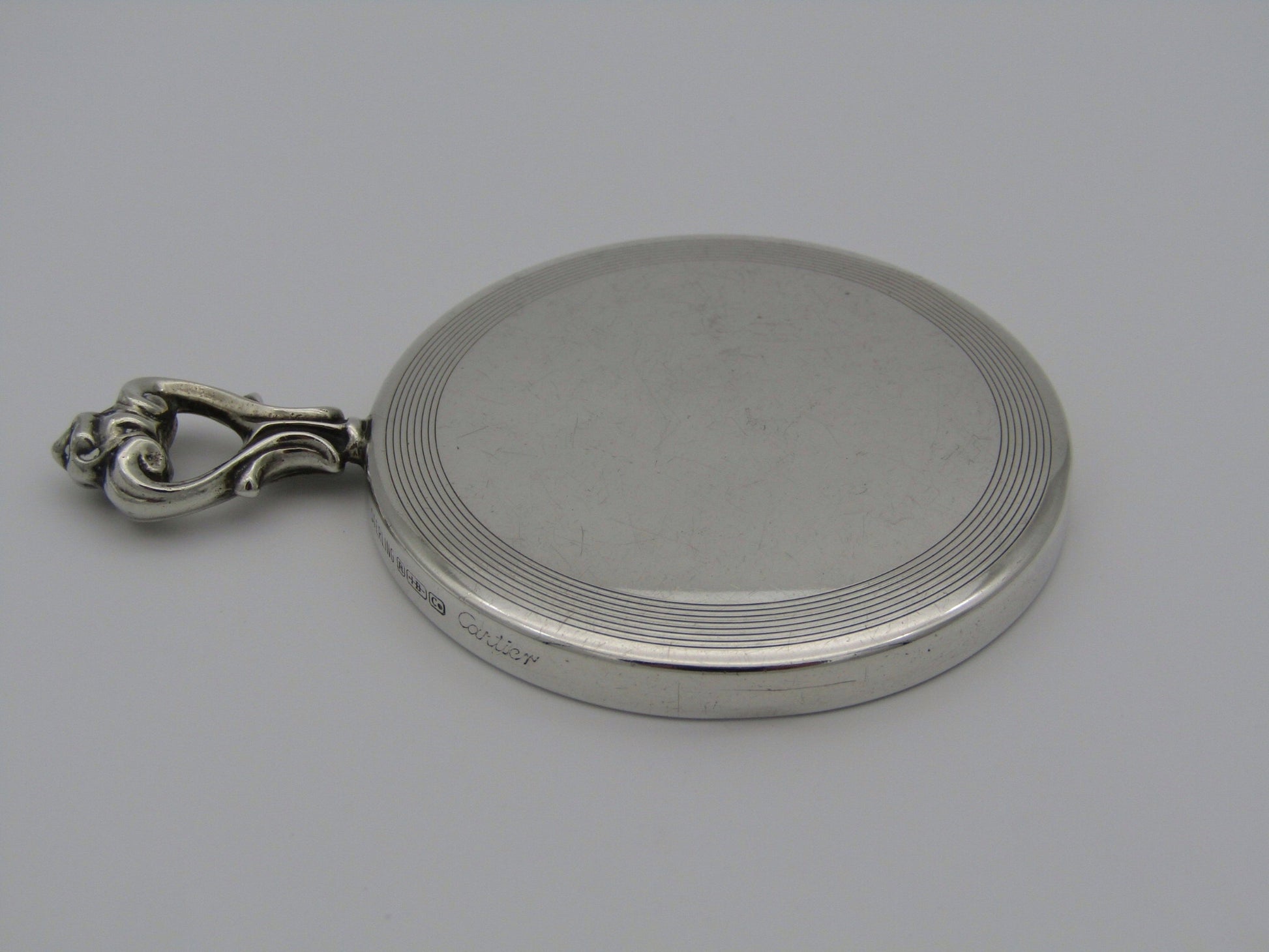 A sterling silver hand mirror by Cartier. Circa 1920s.